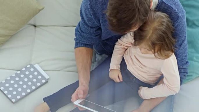 父亲和女孩在平板电脑上观看动画片