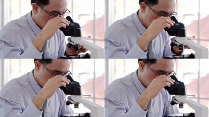 在生命科学实验室工作的卫生保健研究人员。年轻的男性研究科学家在研究实验室准备和分析显微镜载玻片。科学