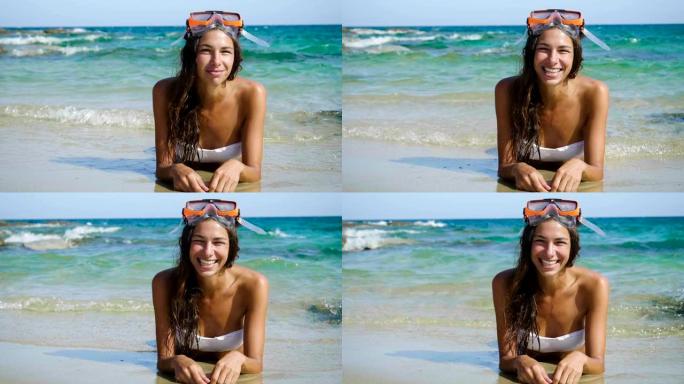 美丽的年轻女子在海上微笑，穿着泳衣戴着潜水面具快乐。