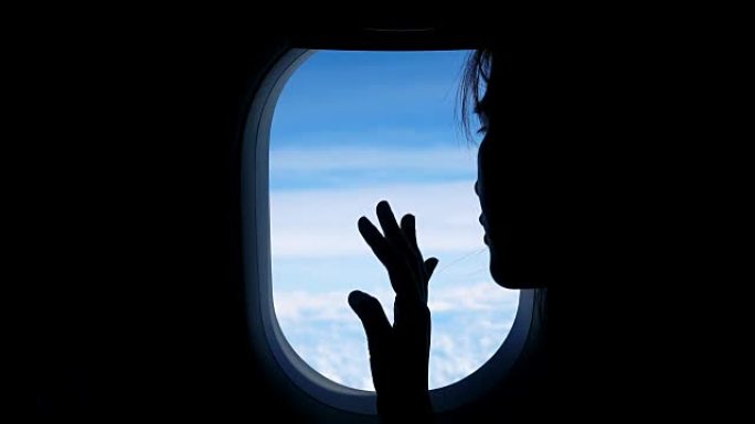 女人透过飞机窗户看