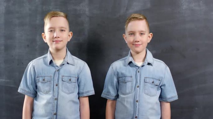 高加索同卵双胞胎在黑板上摆姿势