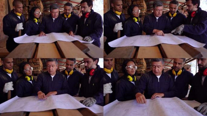 一群拉丁美洲工人在查看木材工厂的蓝图时讨论了一个项目