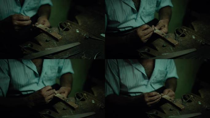 正宗的手工珠宝大师在他的车间里用锉刀/刨丝器做最后的笔触，制作一种新的原创产品。手部特写