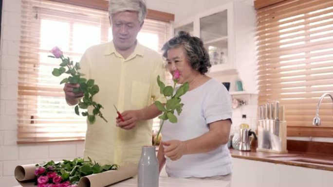 亚洲老年夫妇在家里厨房的木桌上制作花束。中国甜蜜的老年夫妇利用时间在家一起放松。生活方式高级夫妇在家