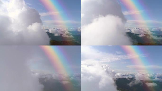 彩虹背景下群山上空的云层飞行。过度下垂