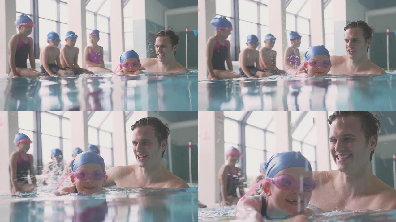 男游泳教练给女孩在游泳池里举行彩车课