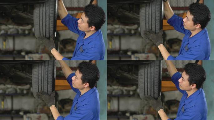 4k: 男性机械师在汽车修理厂检查轮胎。