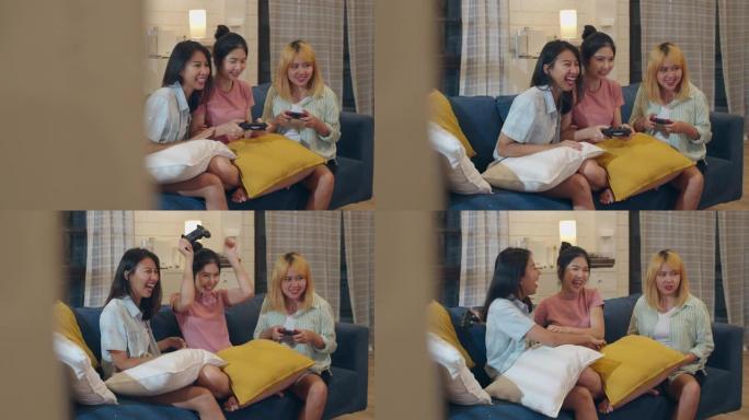 一群亚洲女性夫妇在家玩游戏，女性使用操纵杆在夜晚的客厅沙发上一起度过有趣的时刻。青少年青年朋友足球迷