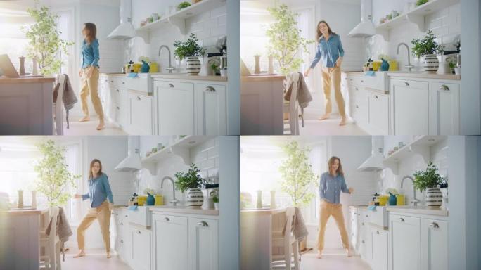 穿着牛仔裤衬衫和棕色裤子的迷人年轻女性正在厨房里创造性地跳舞。阳光现代厨房，拥有健康的生活方式氛围。