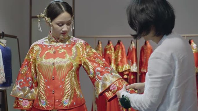 中年中国婚纱设计师试衣袖