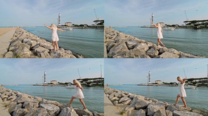WS赤脚年轻女子在意大利普利亚阳光明媚的海上岩石上行走