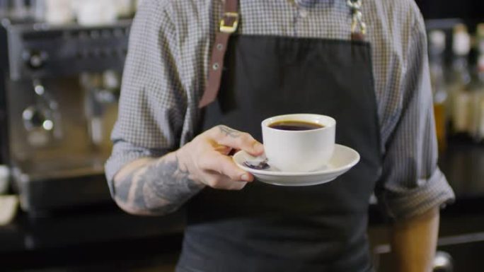 纹身男咖啡师与一杯美式咖啡摆姿势