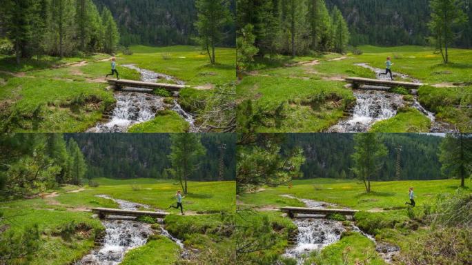 健康的女人在绿草的草地上慢跑，穿过溪流上的桥梁
