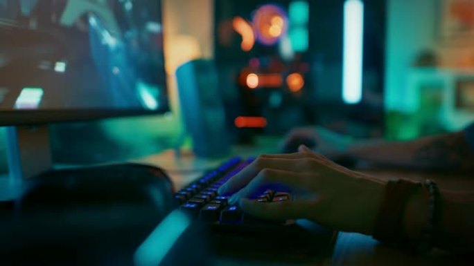 特写镜头显示玩家在玩在线射击视频游戏时按下键盘按钮。键盘发光二极管灯在彩虹光谱中变色。玩家戴着手镯。