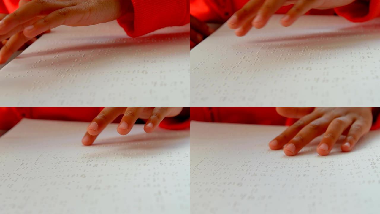 4k学校教室里盲人亚洲男生手读盲文的特写