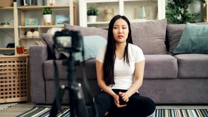 可爱的亚洲女孩女博主正在为她的互联网vlog录制视频，看着相机，笑着说。博客和技术概念。