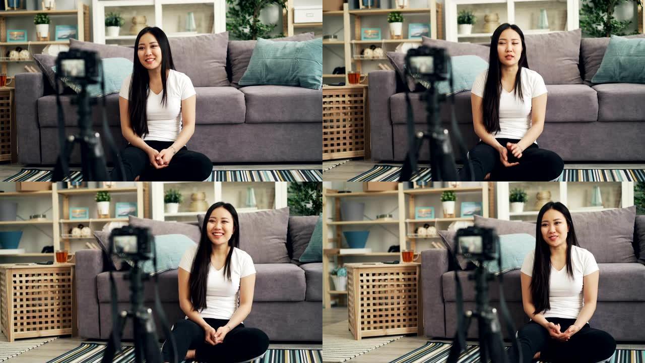 可爱的亚洲女孩女博主正在为她的互联网vlog录制视频，看着相机，笑着说。博客和技术概念。
