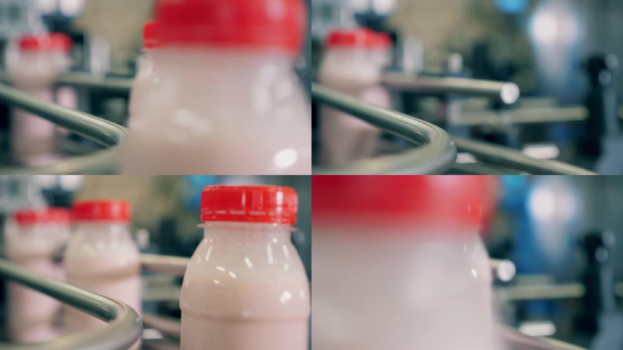 关闭沿输送机移动的未贴标签的酸奶瓶