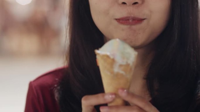 亚洲年轻女子在泰国曼谷旅行，美丽的女性在考山路散步和吃冰淇淋感到快乐。妇女旅游吃街头食品泰国概念。慢