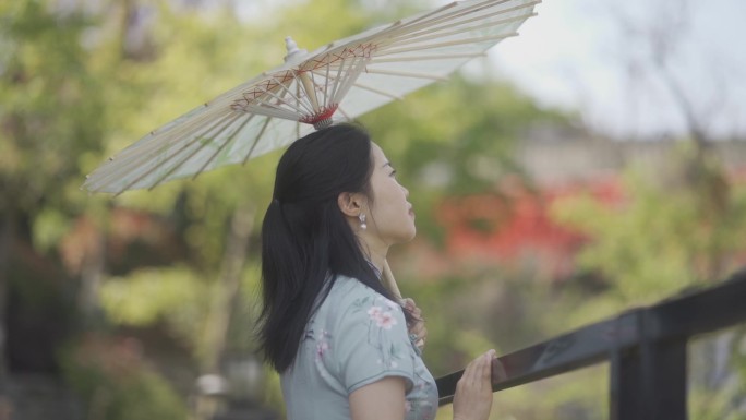 穿旗袍女生撑着油纸伞仰望天空传统服饰文化