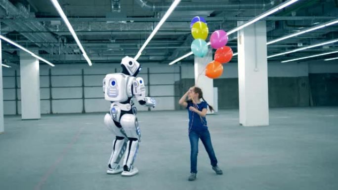 带着气球的快乐女孩正在一个类人猿机器人周围奔跑
