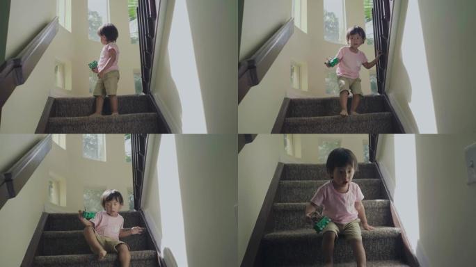 亚洲小男孩坐着爬上台阶