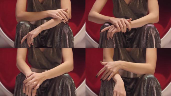 深色指甲的迷人女人轻轻地抚摸着她的手