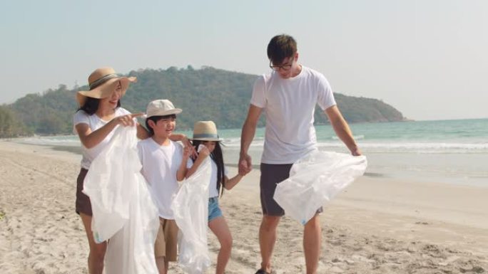 亚洲年轻的幸福家庭活动家收集塑料垃圾并在海滩上散步。慢动作镜头。
