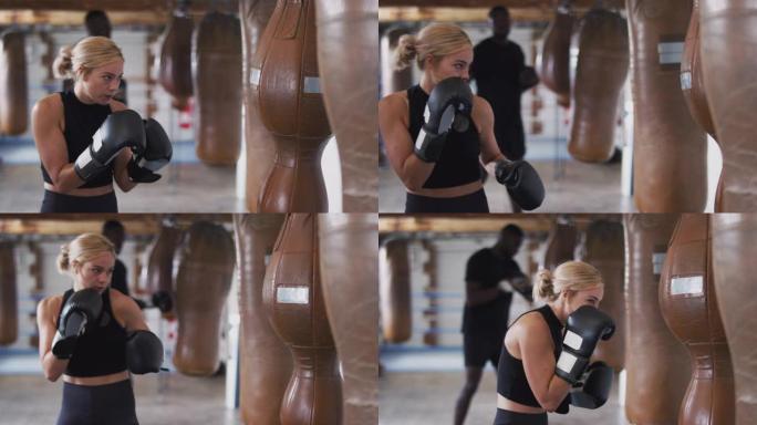 健身房训练中的女拳击手，配有老式皮革打孔袋