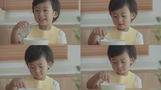 微笑的小男孩在高脚椅上吃饭