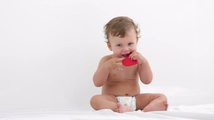 一个可爱的婴儿穿着尿布坐起来的肖像。