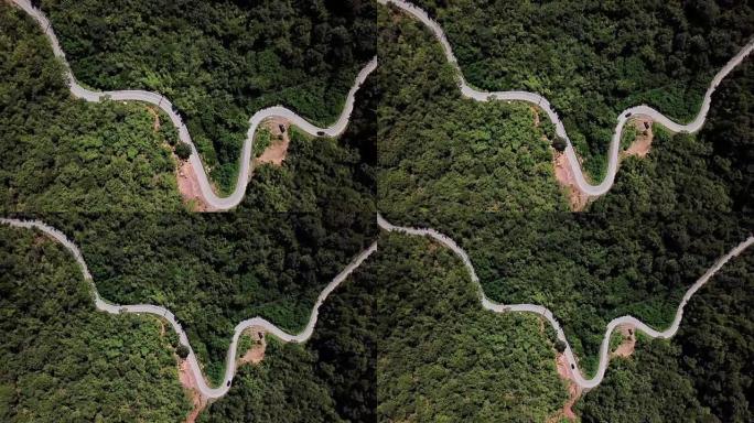 森林中蜿蜒道路的鸟瞰图和汽车驾驶，安全驾驶理念