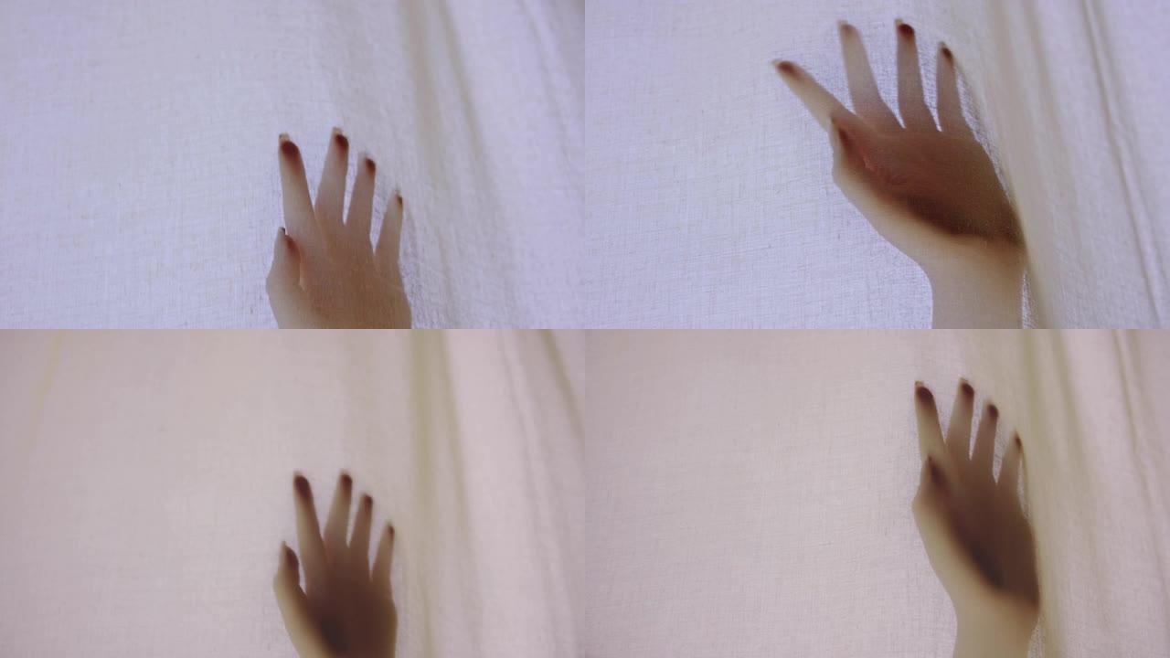 透明窗帘后面的女人的手