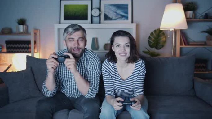 幸福夫妻男女深夜在家玩电子游戏微笑