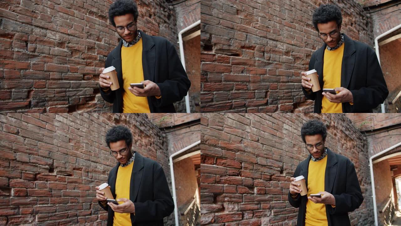 非裔美国人在户外使用智能手机拿着咖啡的慢动作