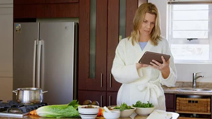 女人在4k厨房的数字平板电脑上检查食谱