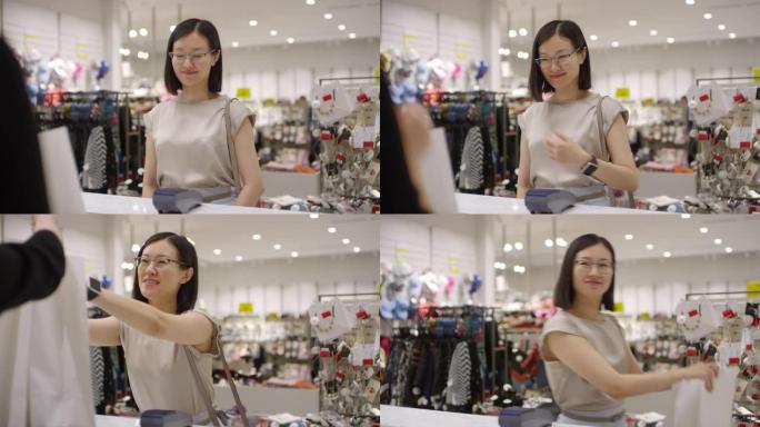 中国女孩在时装店用智能手表付款购买