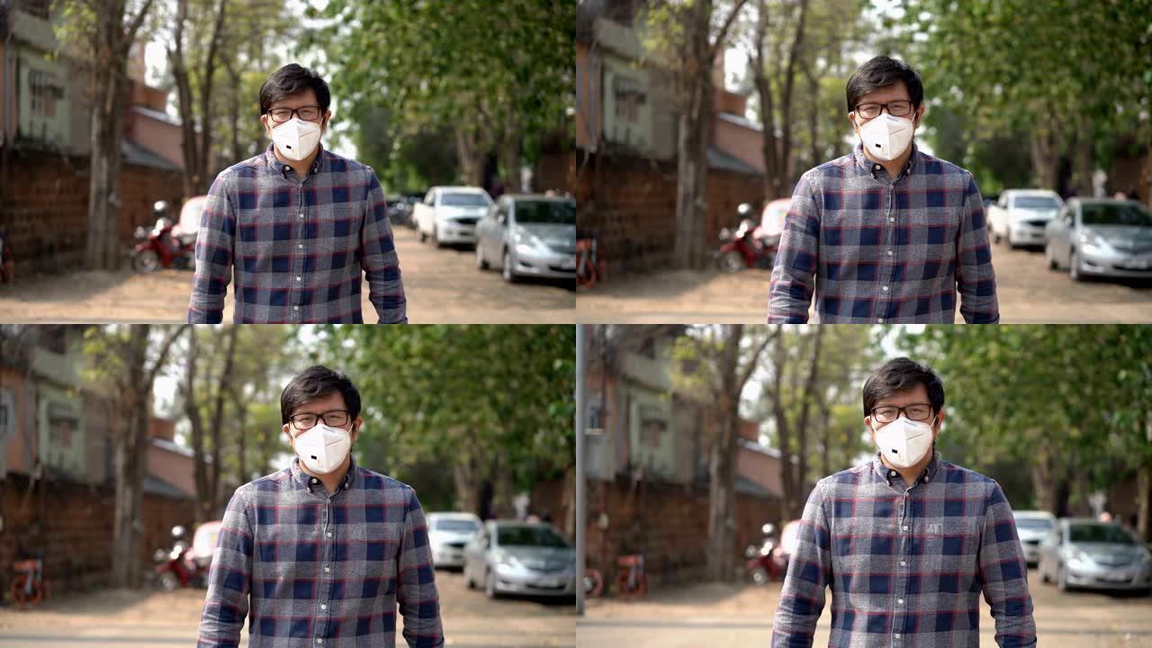戴空气污染面具的亚洲男子在城市行走的前视图泰国清迈