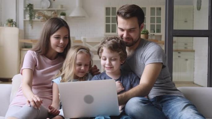 友好幸福的四口之家喜欢在家使用笔记本电脑