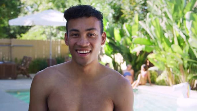 微笑着赤裸胸的非洲裔美国男子在户外与朋友一起享受夏季泳池派对
