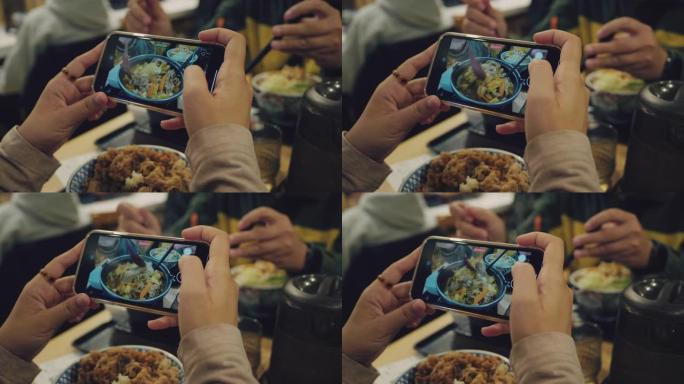 女性手通过现代智能手机拍摄食物照片。