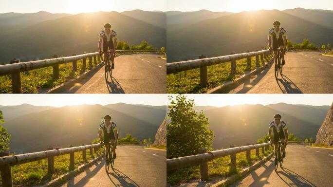 专业的公路骑车人被阳光照亮，在日落时站起来踩踏板