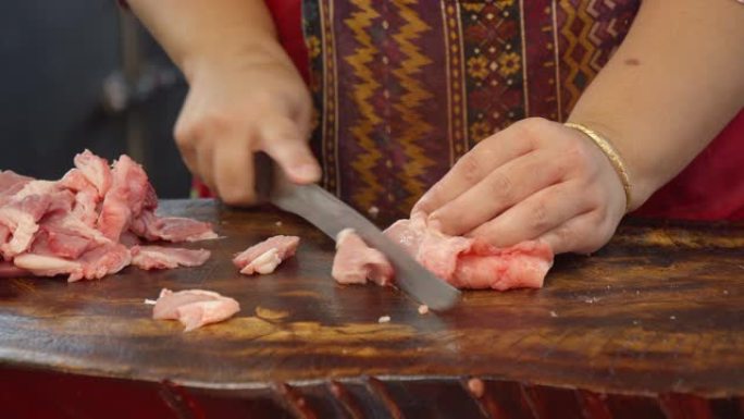 亚洲屠夫用刀切成新鲜的生牛肉