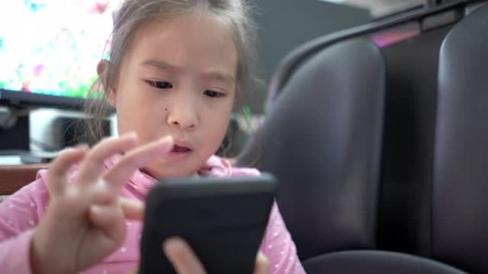在父亲的工作区使用智能手机的可爱女孩
