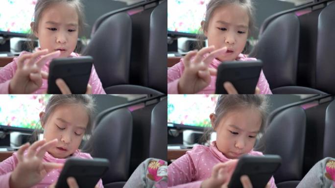 在父亲的工作区使用智能手机的可爱女孩