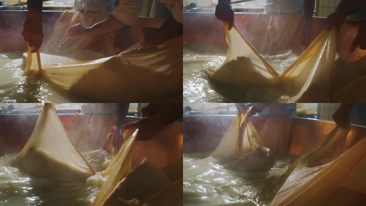 奶酪制造商的慢动作特写镜头正在按照古老的意大利传统使用新鲜和生物牛奶准备一种形式的帕尔马干酪