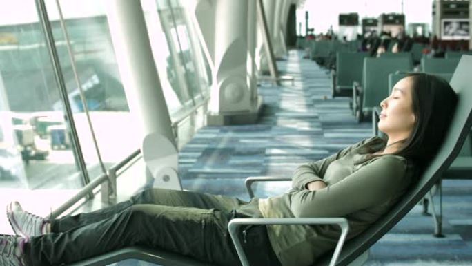 在机场睡觉的亚洲妇女