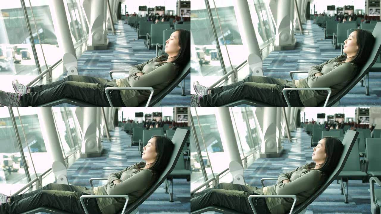 在机场睡觉的亚洲妇女