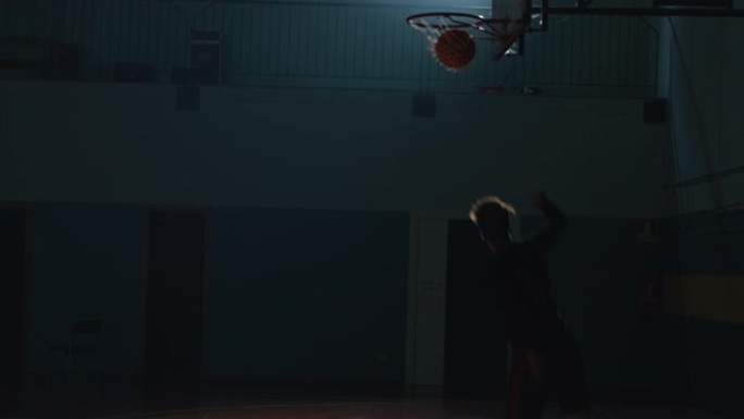 电影慢动作特写垂直镜头的年轻职业男球员正在健身房练习篮球锻炼