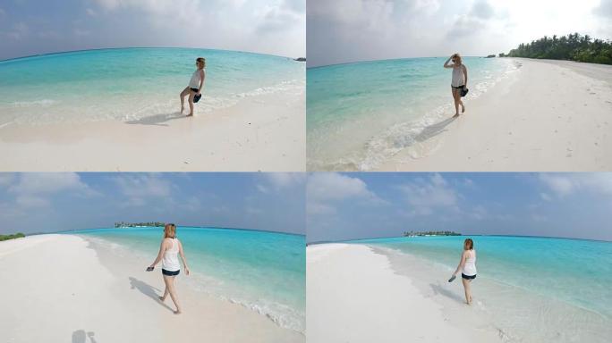 女士女士在马尔代夫阳光海滩的海浪中漫步